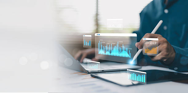 analista de negócios usando tablet digital e laptop com painel de dados interativos, gráficos financeiros, relatórios analíticos e métricas de desempenho para inteligência de negócios, planejamento estratégico orientado por dados - mulher de negócios olhando tablet digital no calendário - fotografias e filmes do acervo