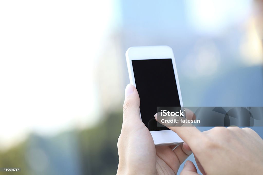 Touching Smart Phone In the sunny environment using mobile phones. Human Hand Stock Photo