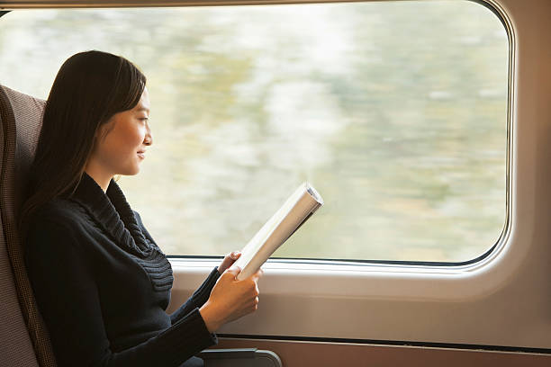 Young Woman Reading a Magazine While Riding the Train