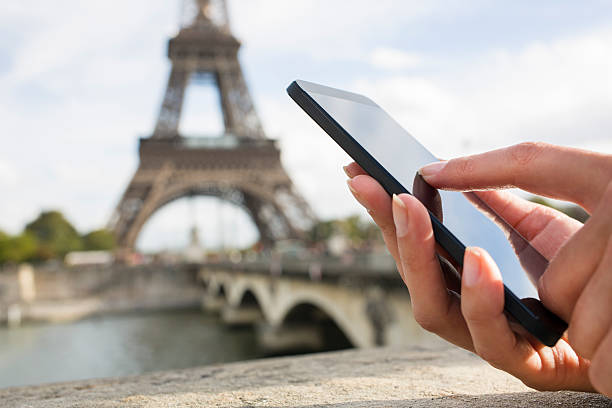 Woman using her Mobile Phone in front of Eiffel Tower stock photo