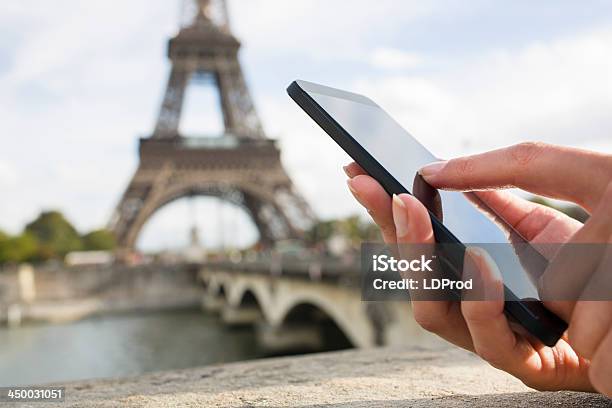 Woman Using Her Mobile Phone In Front Of Eiffel Tower Stock Photo - Download Image Now