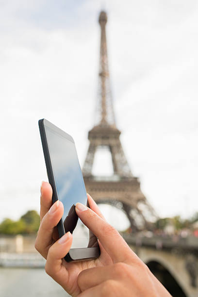 istock Woman holding smartphone over a blurred Eiffel Tower 450031061