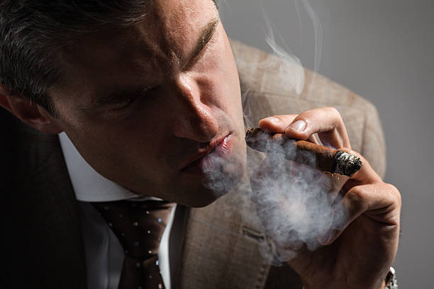 istock Elegant businessman smoking a cuba cigar 450031535