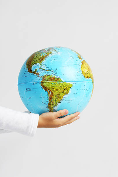 istock Children's hands holding globe on white background 450038139