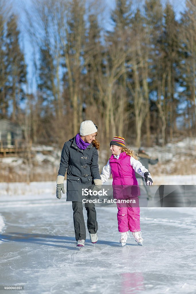 Mother and daughter Mother and daughter skating on a pond. Child Stock Photo