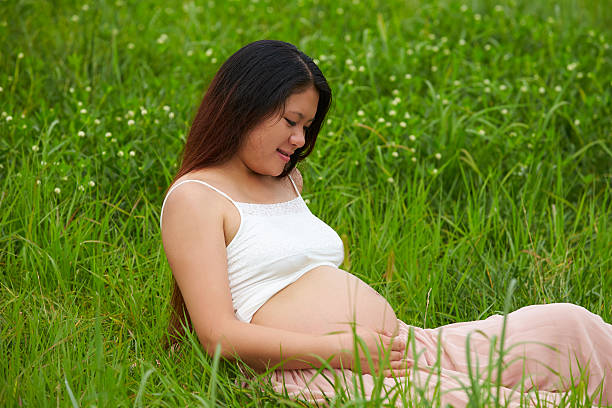 istock pregnant woman looking ather belly 450048427