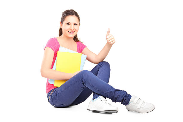istock Young female student sitting on floor and giving thumb up 450055147