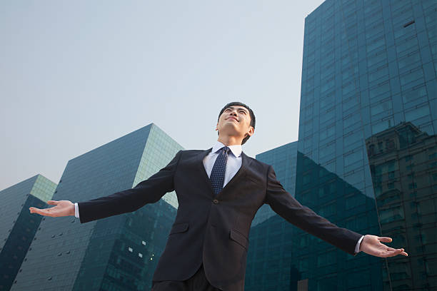 istock Young businessman standing outside with arms outstretched 450055851