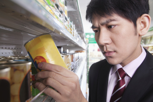 Businessman looking at can in the  Supermarket