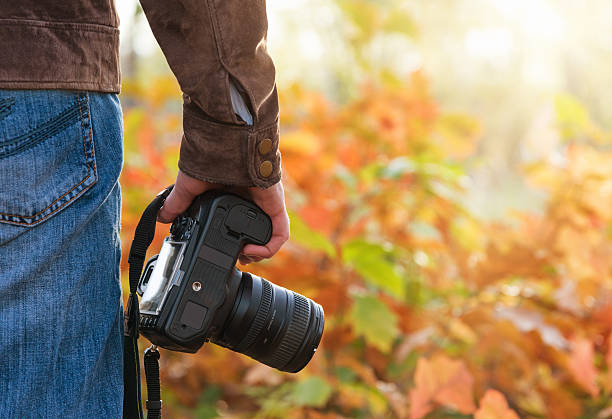 istock Photographer holding camera in the park 450056763