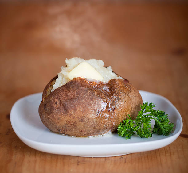 A picture of a baked potato on a white plane Fresh baked potato on a white plate baked potato stock pictures, royalty-free photos & images