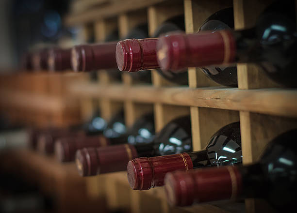 istock Red wine bottles stacked on wooden racks 450062565