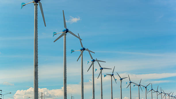 istock white wind turbine generating electricity on blue sky 450067177