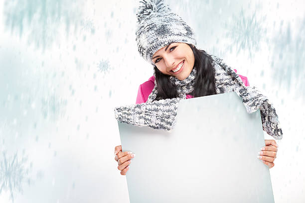 istock smiling girl with a blank board and around snowing 450070251