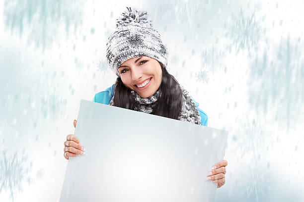 istock smiling girl with a blank board and around snowing 450071127