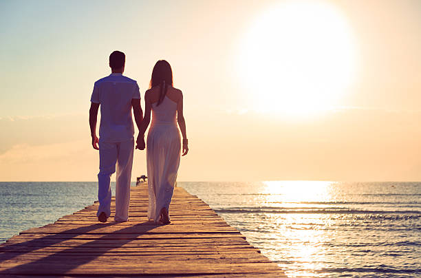 istock young couple walking on pier 450087527