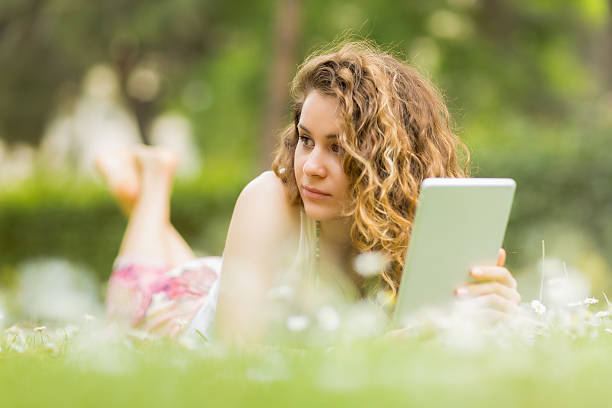 istock Confident young woman with Tablet PC in the park 450088531