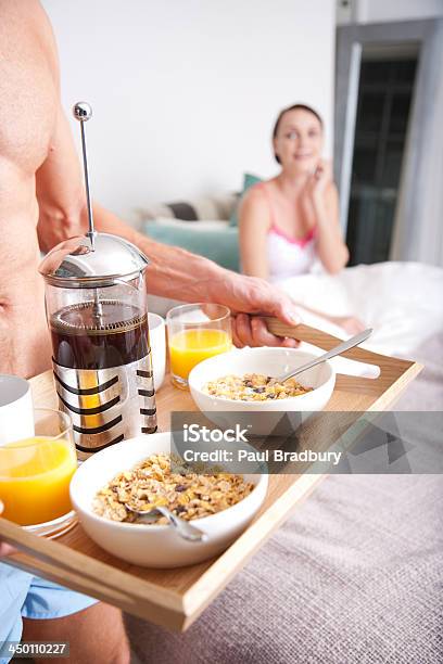 Foto de Homem Levando Uma Mulher Cafédamanhã Na Cama e mais fotos de stock de Bandeja - Bandeja, Café da manhã, Cama