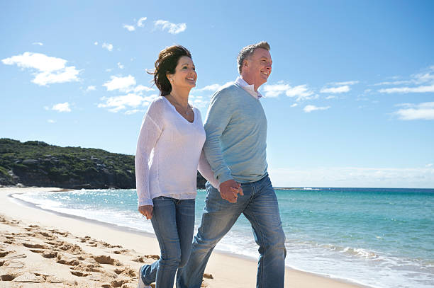 istock Mature couple walking along the beach 450111239