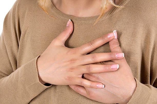 mujer con dolor de pecho - hand on heart fotografías e imágenes de stock