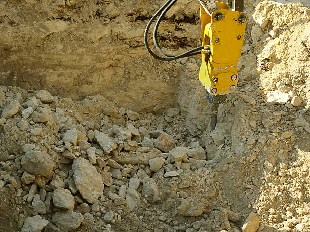 istock Excavator with Hydraulic hammer demolishes stone 450116231