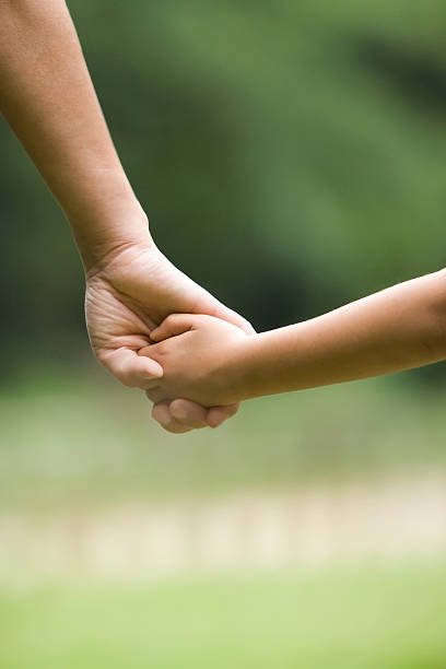 istock Mothers hand holding kids hand. 450118343