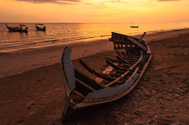istock Silhouette boat at beach and sunset 450138651