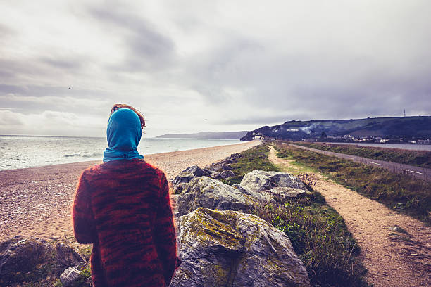 istock Woman walking along coastal path on beach in autumn 450141677