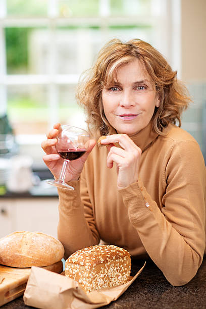 istock mature woman enjoying wine and bread 450151037