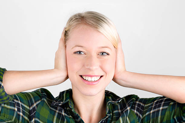 istock attraktive young blond woman plugs her ears 450151237