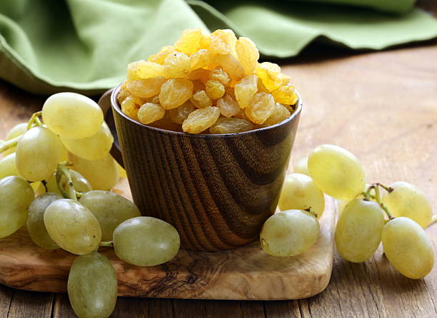 istock dried white grapes (raisins) on a wooden table 450151371
