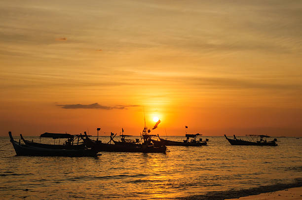 istock Silhouette boat at beach and sunset 450152715