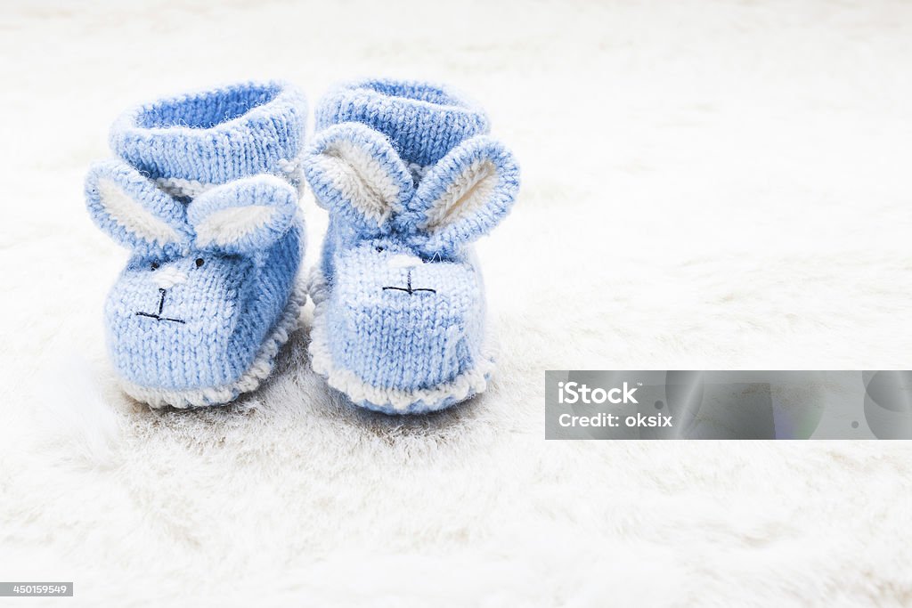 Knitted baby booties Knitted blue baby booties with rabbit muzzle for little boy Baby - Human Age Stock Photo