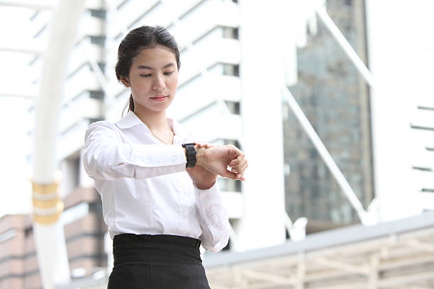 istock Business woman checking the time with modern building background 450161455