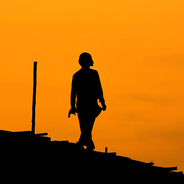 istock Silhouette of construction workers on scaffold working under a h 450168655