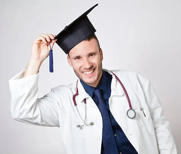 Photo of young doctor smiling with mortarboard