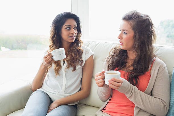 istock Girls sitting on the sofa  drinking coffee 450214581