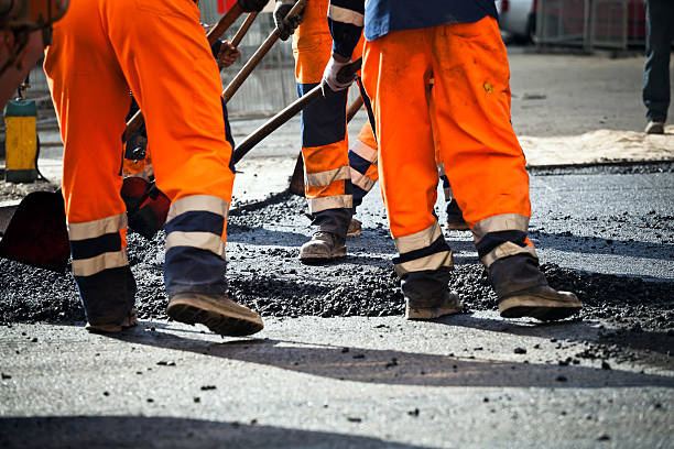 arbeitnehmer auf straßenarbeiten - road construction stock-fotos und bilder