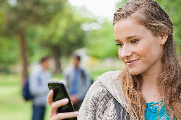 istock Close up of a blonde student using her smartphone 450235989