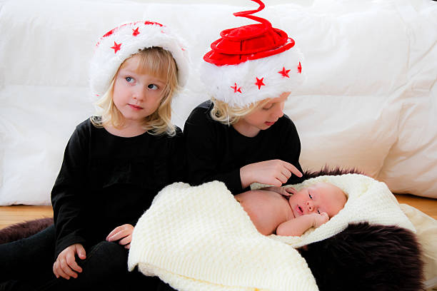 かわいい赤ちゃんの姉妹クリスマスの準備をいたします。 - parker brothers 写真 ストックフォトと画像