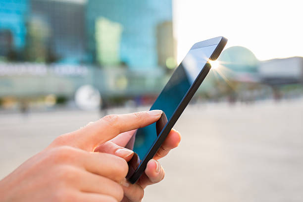 istock Businesswoman using her mobile phone in front of Building 450251407