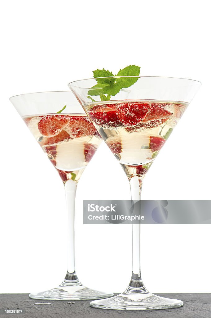 strawberry cocktail with berry in martini glass isolated on white strawberry cocktail with berry in martini glass isolated on white background. festive arrangement with sparkling wine and fresh berries. selective focus Champagne Stock Photo