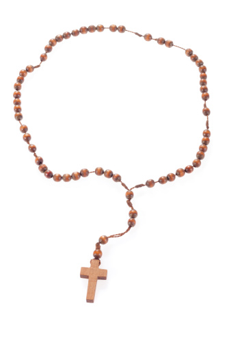 An old man prays rosaries and crosses
