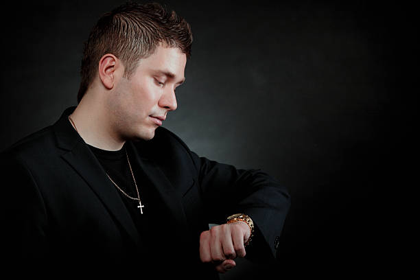 istock Worried man looking at watch on black 450271041