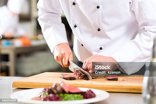 Chef Cocina Preparando La Comida En El Restaurante Foto de stock y más banco de imágenes de Chef - Chef, Bistec, Cocinar