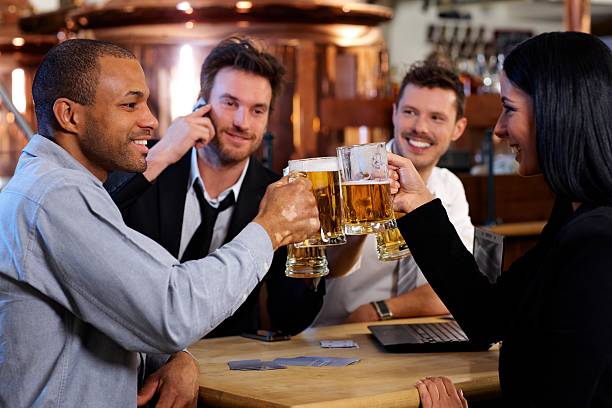 Young office workers toasting with beer at pub stock photo