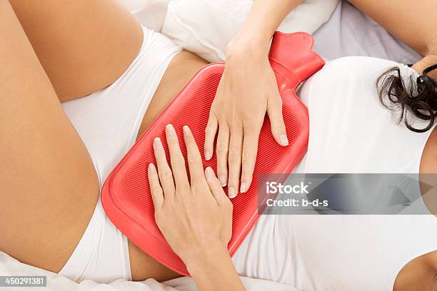 Young Woman In Underwear Holding Hotwater Bag On Belly Stock Photo - Download Image Now