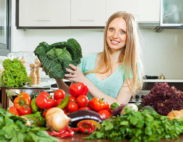 istock happy housewife with raw cabbage and  vegetables 450291569
