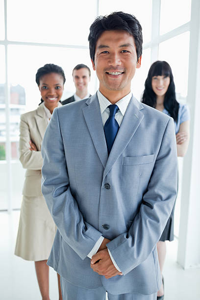 istock Four smiling business people standing upright 450297365