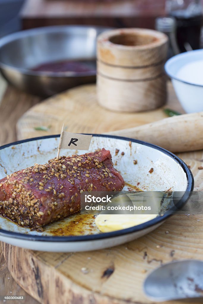 Marinating Steak A raw cut of fillet steak, being marinated and seasoned before cooking. Butter Stock Photo